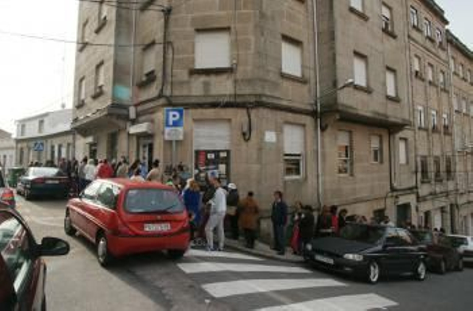 Las personas guardan cola ante la sede de AFAN en donde se reparten las bolsas solidarias.