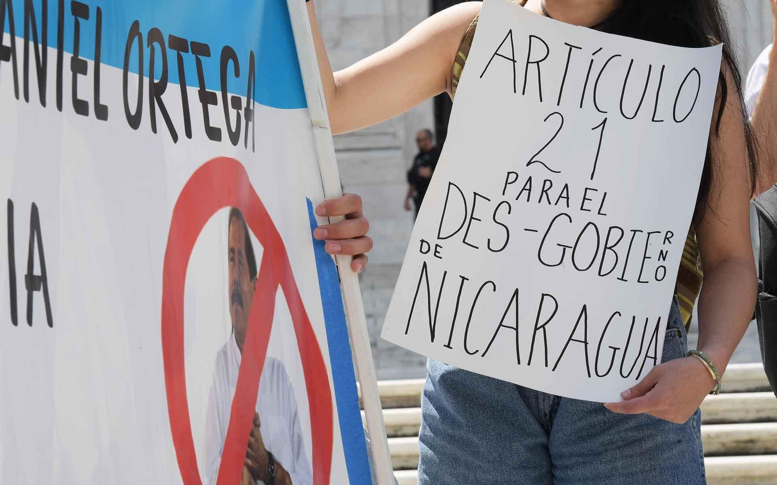USA328. WASHINGTON (ESTADOS UNIDOS), 15/06/2021.- Una persona sostiene un cartel que pide el artículo 21 de la Carta Democrática Interamericana (suspensión de ejercicio) durante un plantón frente a la sede de la Organización de Estados Americanos (OEA), hoy, en Washington (Estados Unidos). A pesar de sus diferencias sobre la situación de Nicaragua, una amplia mayoría compuesta por 26 países se unió este martes en la Organización de Estados Americanos (OEA) para exigir al presidente nicaragüense, Daniel Ortega, la liberación "inmediata" de los aspirantes presidenciales detenidos. EFE/ Lenin Nolly