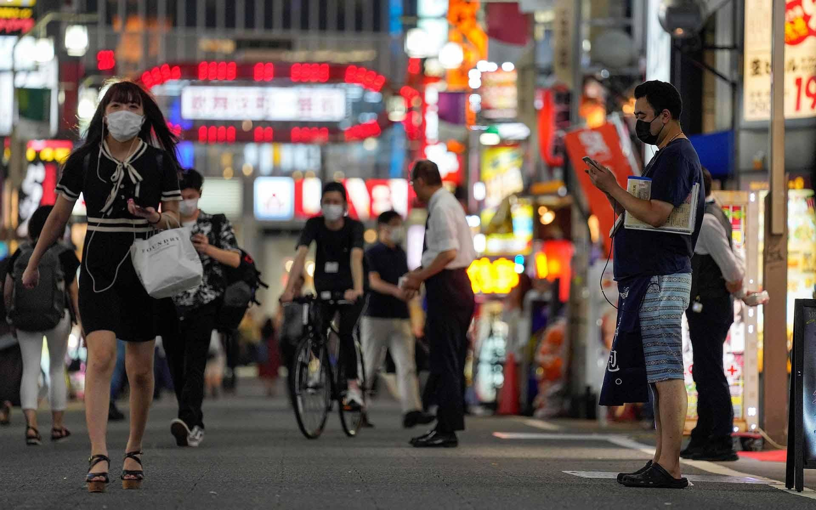 El personal de restaurantes y tiendas tratan de atraer a los peatones en Kabukicho, el área de entretenimiento nocturno más grande de Japón en Shinjuku, en Tokio, Japón. EFE/EPA/KIMIMASA MAYAMA