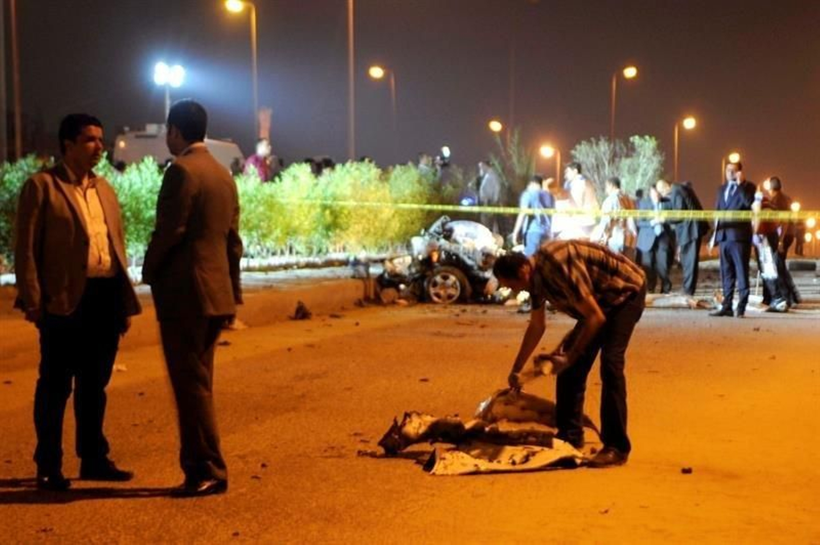 Funcionarios de seguridad egipcios inspeccionan la escena después de la explosión de una bomba.