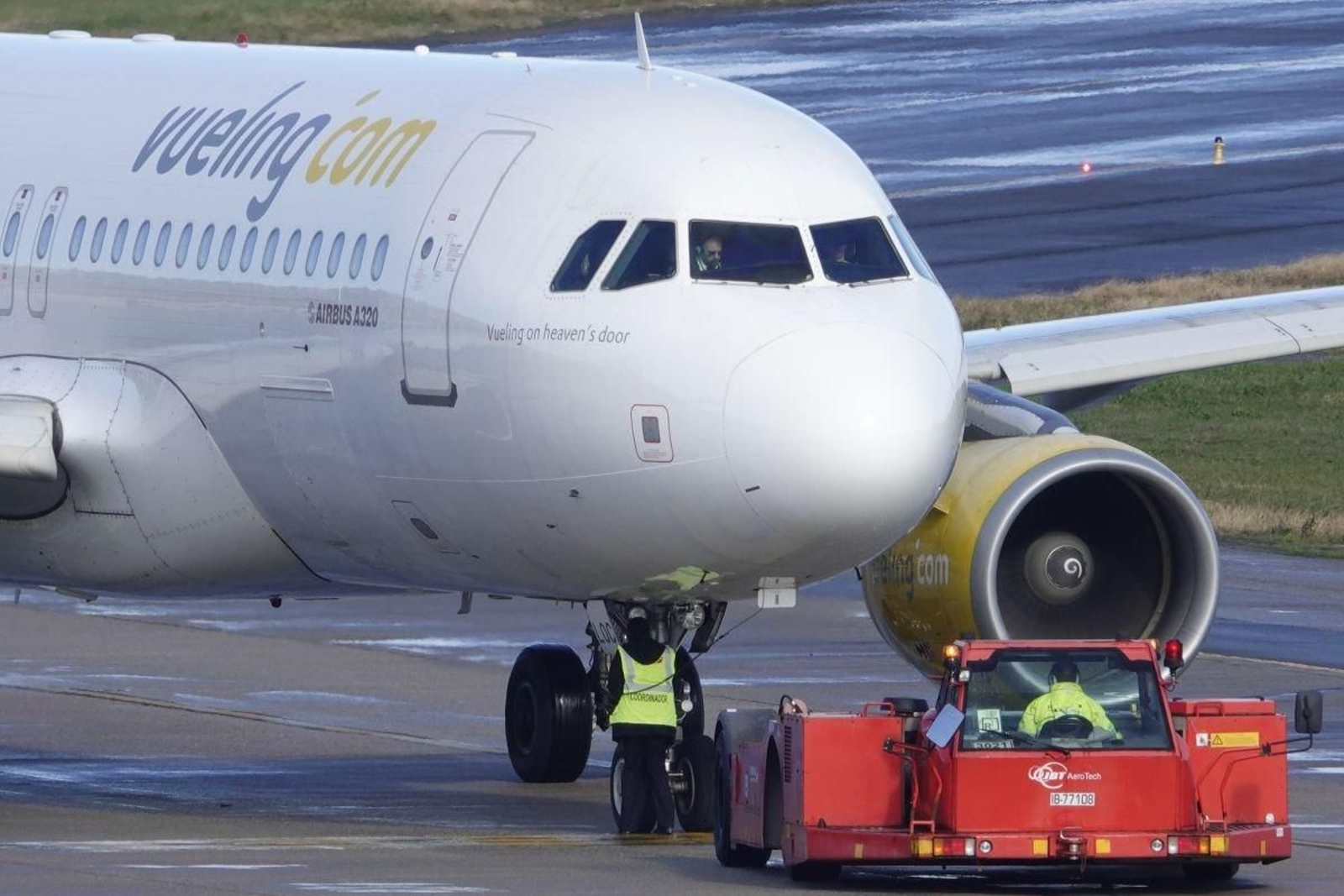 Un avión de la compañía Vueling, tras aterrizar en la pista de Peinador y ser revisados por operarios del aeropuerto.