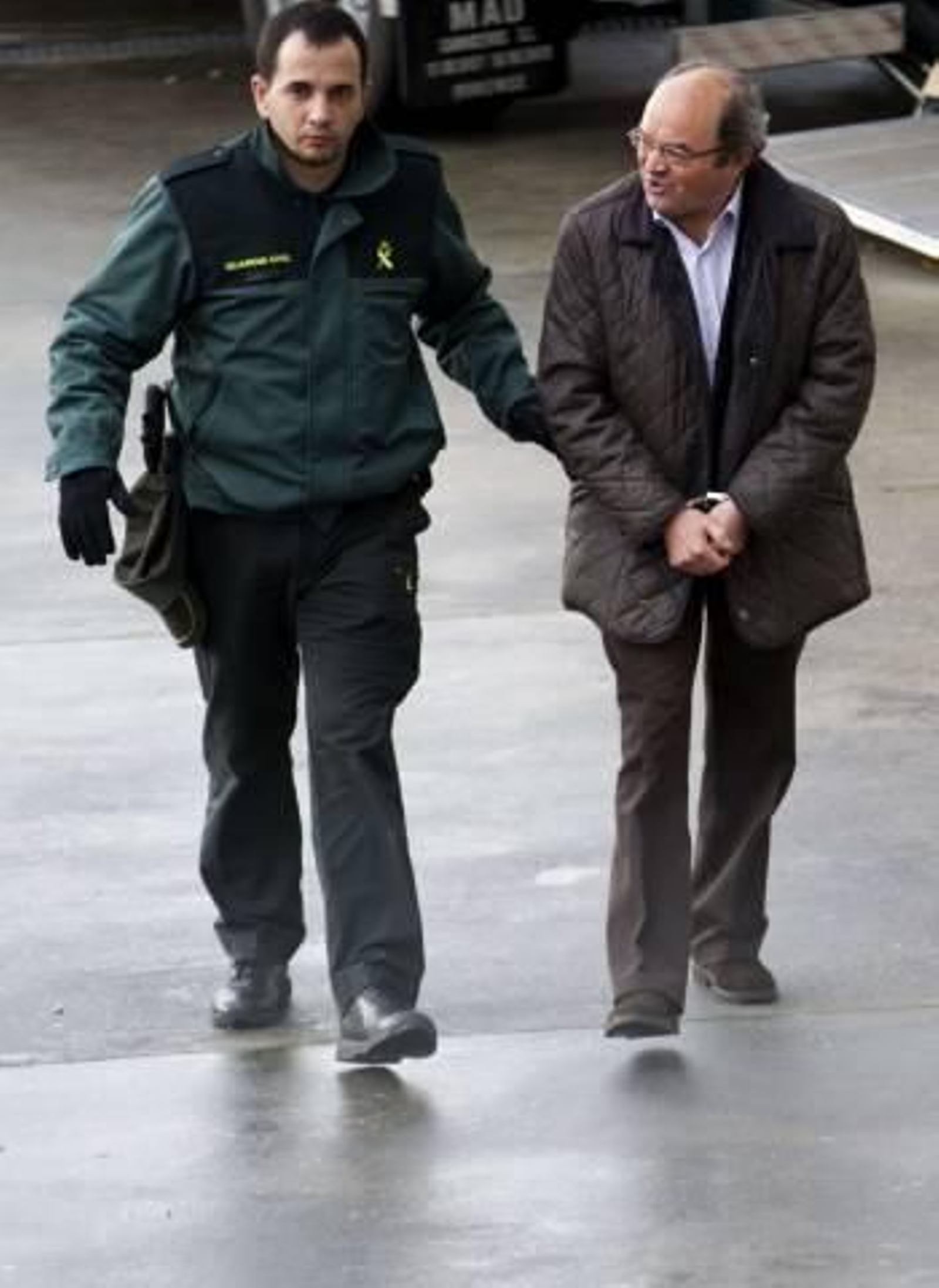 Un agente conduce a Fernández Liñares a los juzgados lucenses, el pasado 5 de diciembre. (Foto: ELISEO TRIGO)