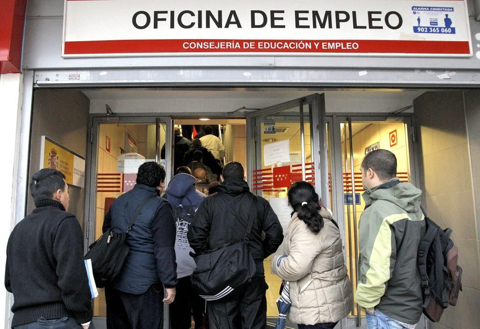 un grupo de personas hace cola para acceder a una oficina de Empleo de Madrid.