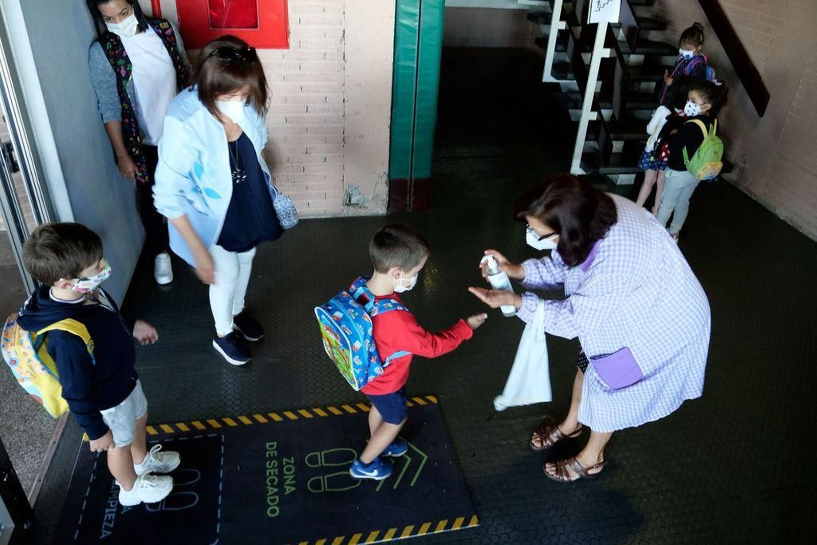 Desinfección de las manos de los niños al entrar en el colegio Lopez Ferreiro de Santiago.