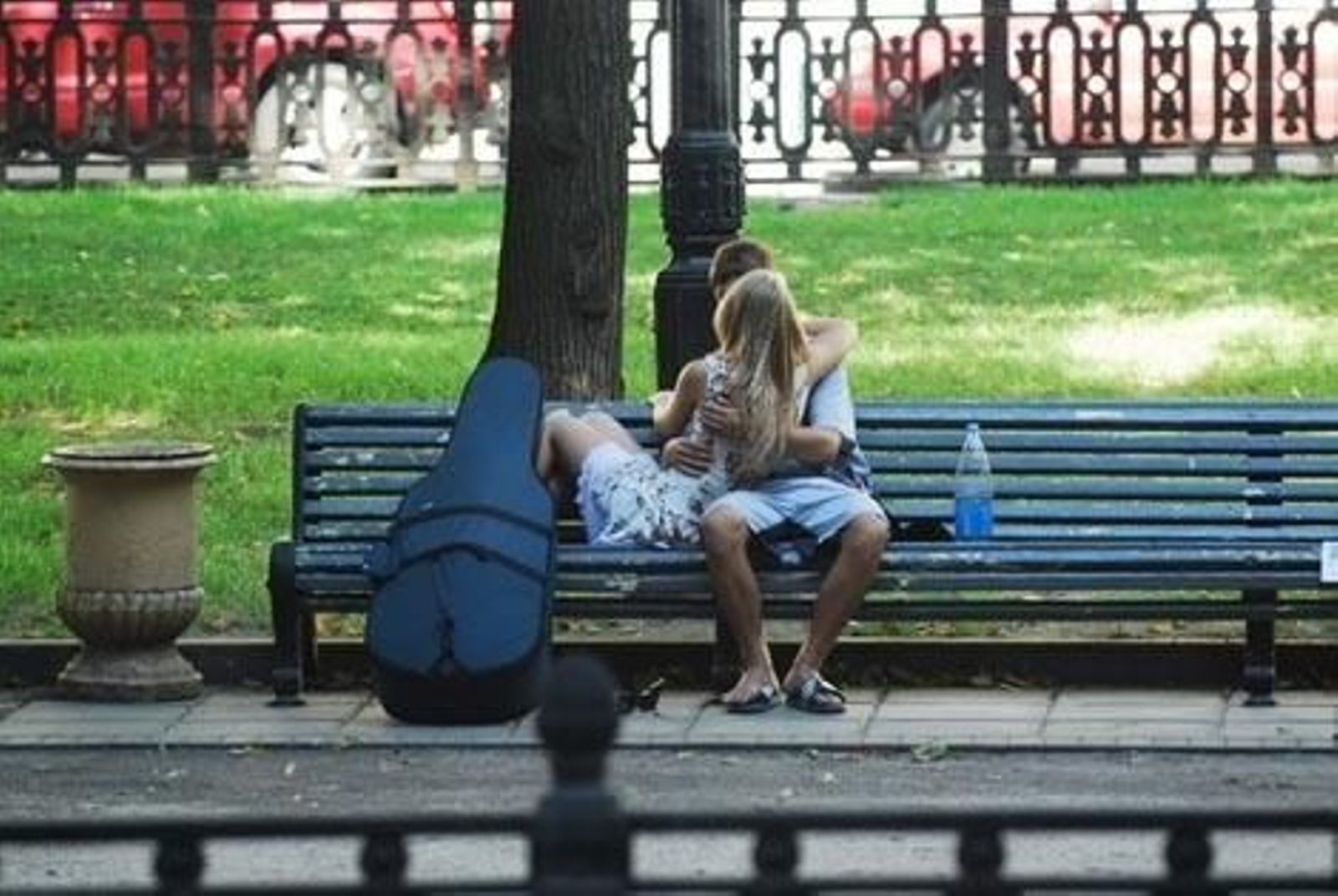 Un pareja de jóvenes, besándose en un parque.