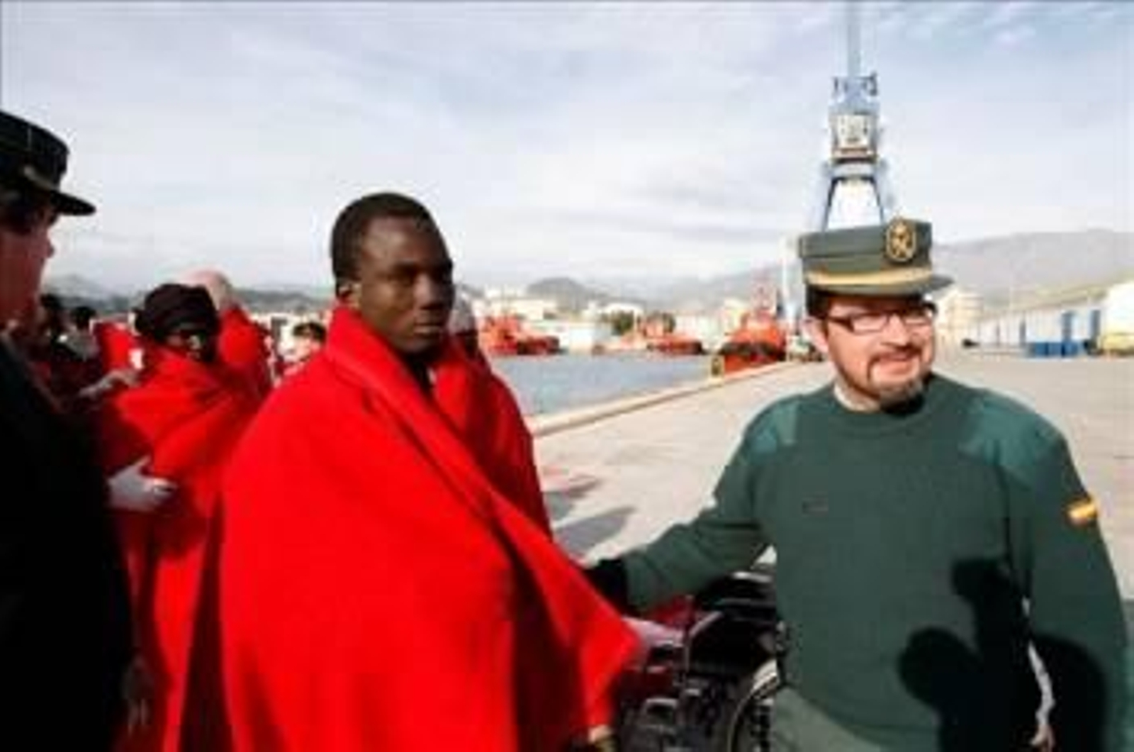 Agentes de la Guardia Civil acompañan a varios de los inmigrantes que han sido interceptados en el día de hoy en la localidad granadina de Motril.