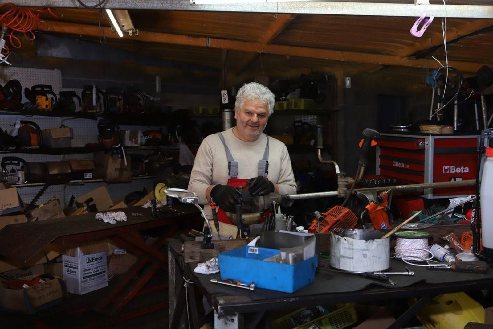 Dorindo Costas reparando, ayer, una máquina en la mesa de trabajo del taller.
