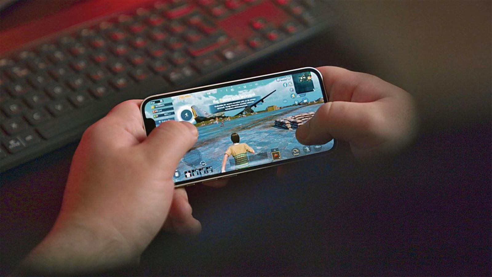 Un niño jugando a un videojuego en un teléfono móvil.