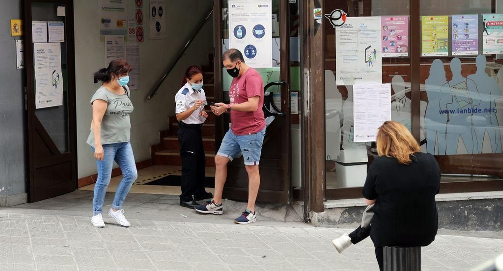 Varias personas hacen cola en una oficina de empleo en Bilbao.
