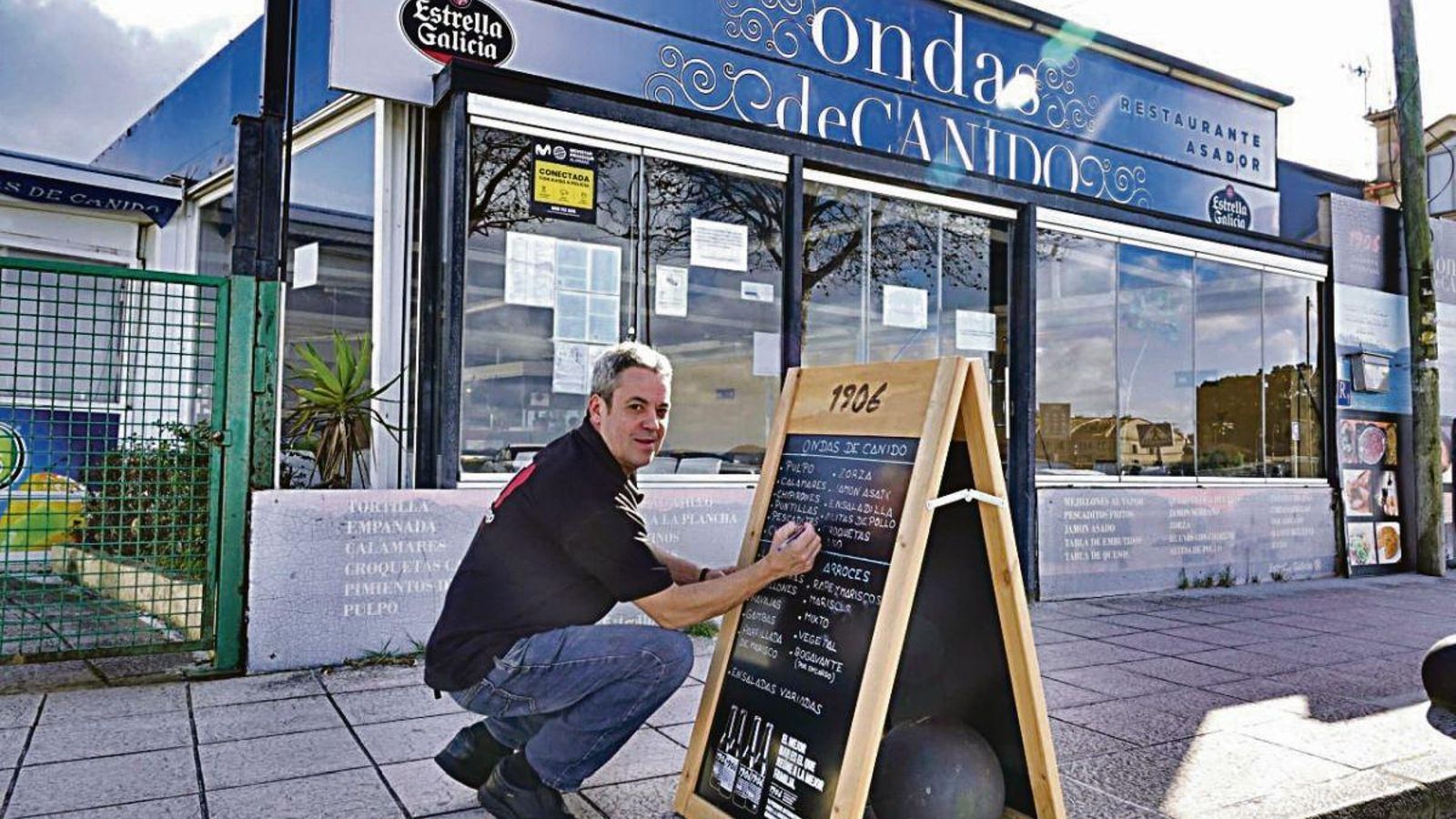 Jorge, propietario de Ondas de Canido, apunta en su pizarra los platos que componen su menú del día.