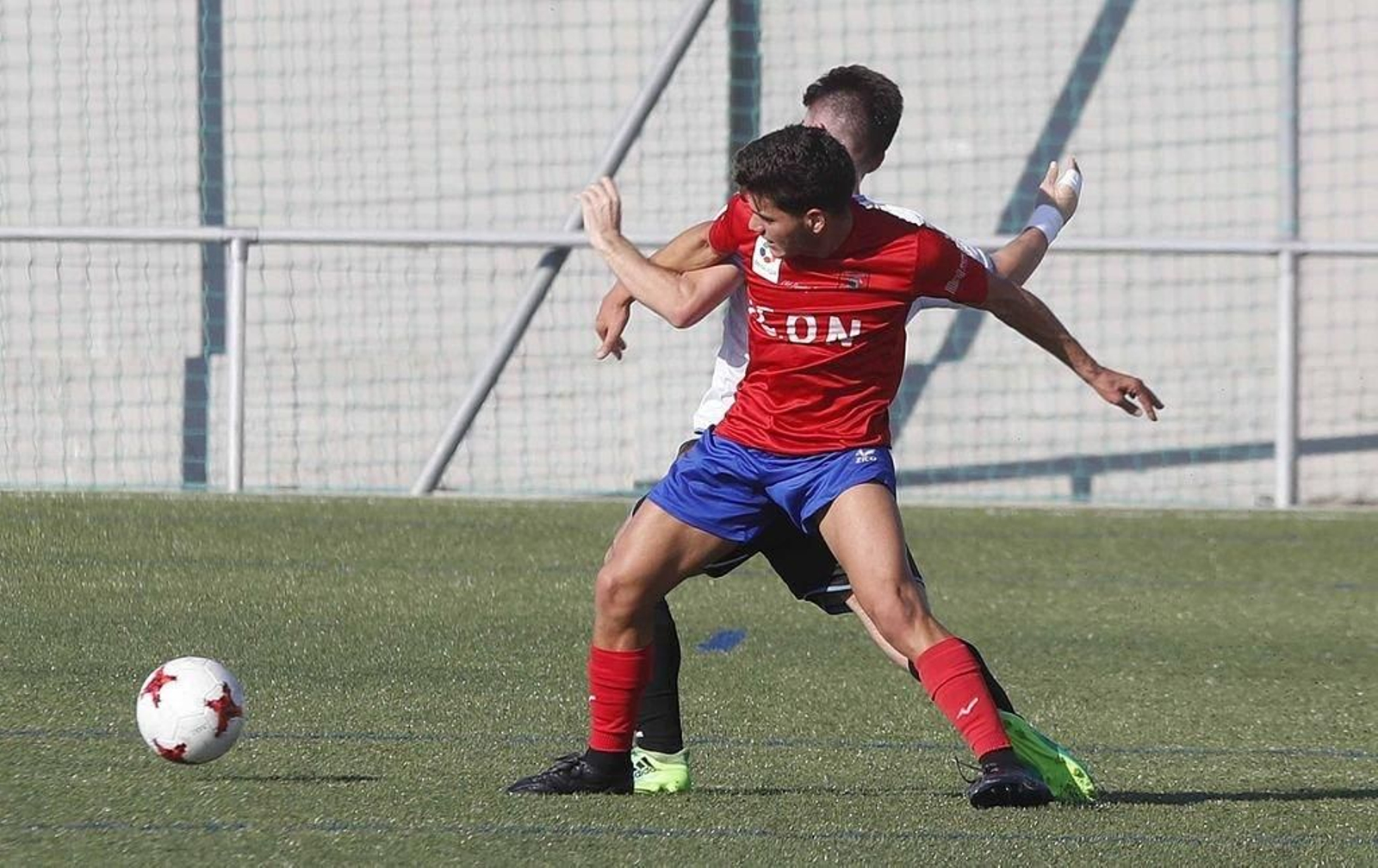 Ricar tenta gañar o balón ante a oposición dun rival nun partido desta tempada.