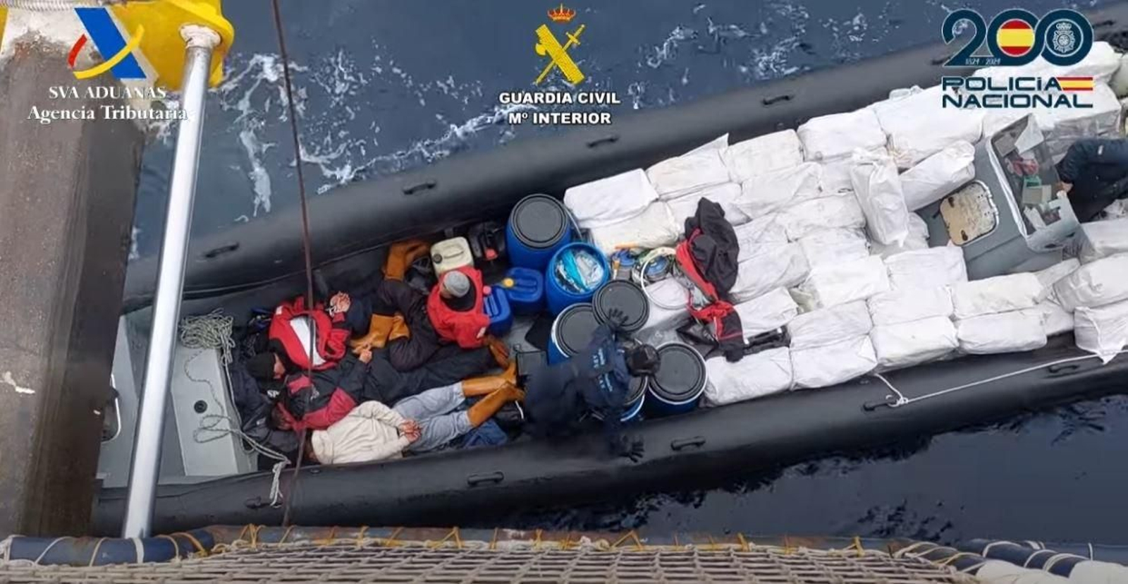 Actuación de los agentes con los tripulantes de la narcolancha ya detenidos y el cargamento de cocaína visible. // Policía Nacional