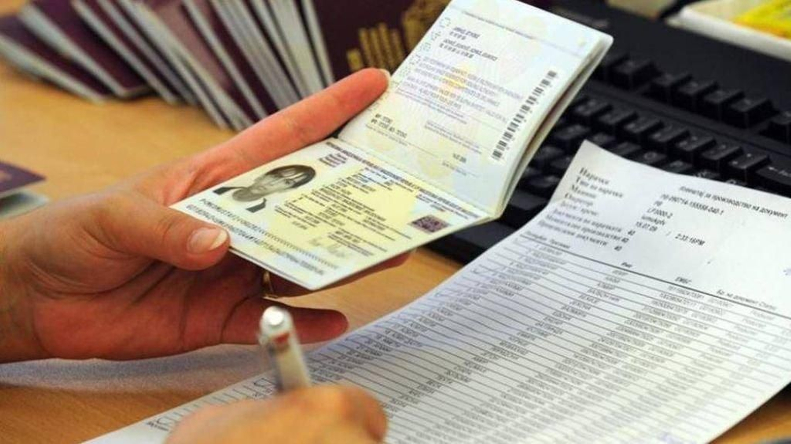 Una funcionaria comprueba los datos de un pasaporte.