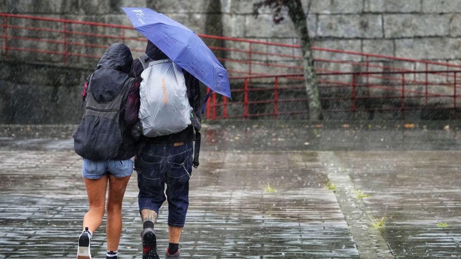 Dos personas se protegen de la lluvia en Vigo.