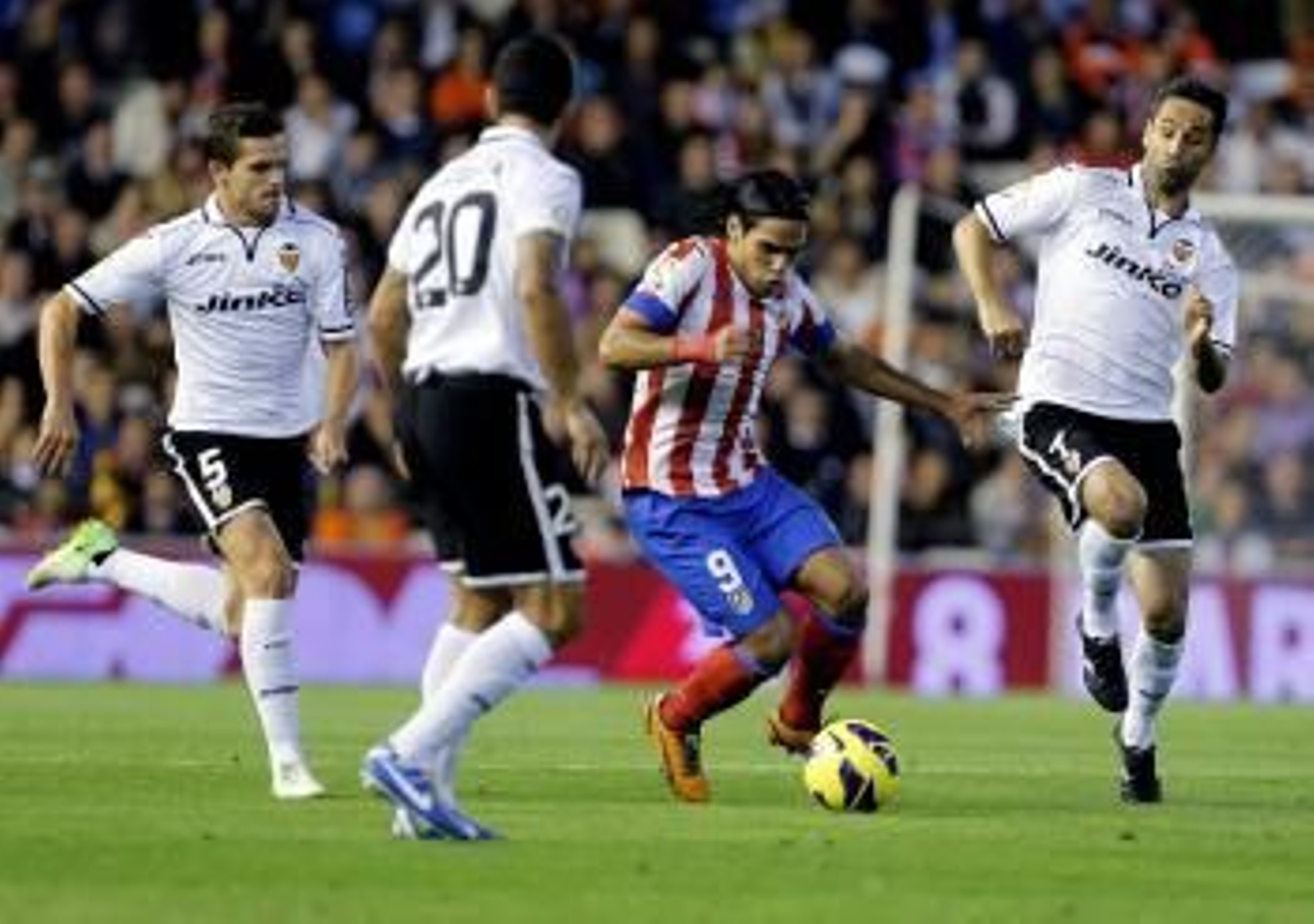 Radamel Falcao conduce el balón entre los valencianistas Gago, Ricardo Costa y Jonas.