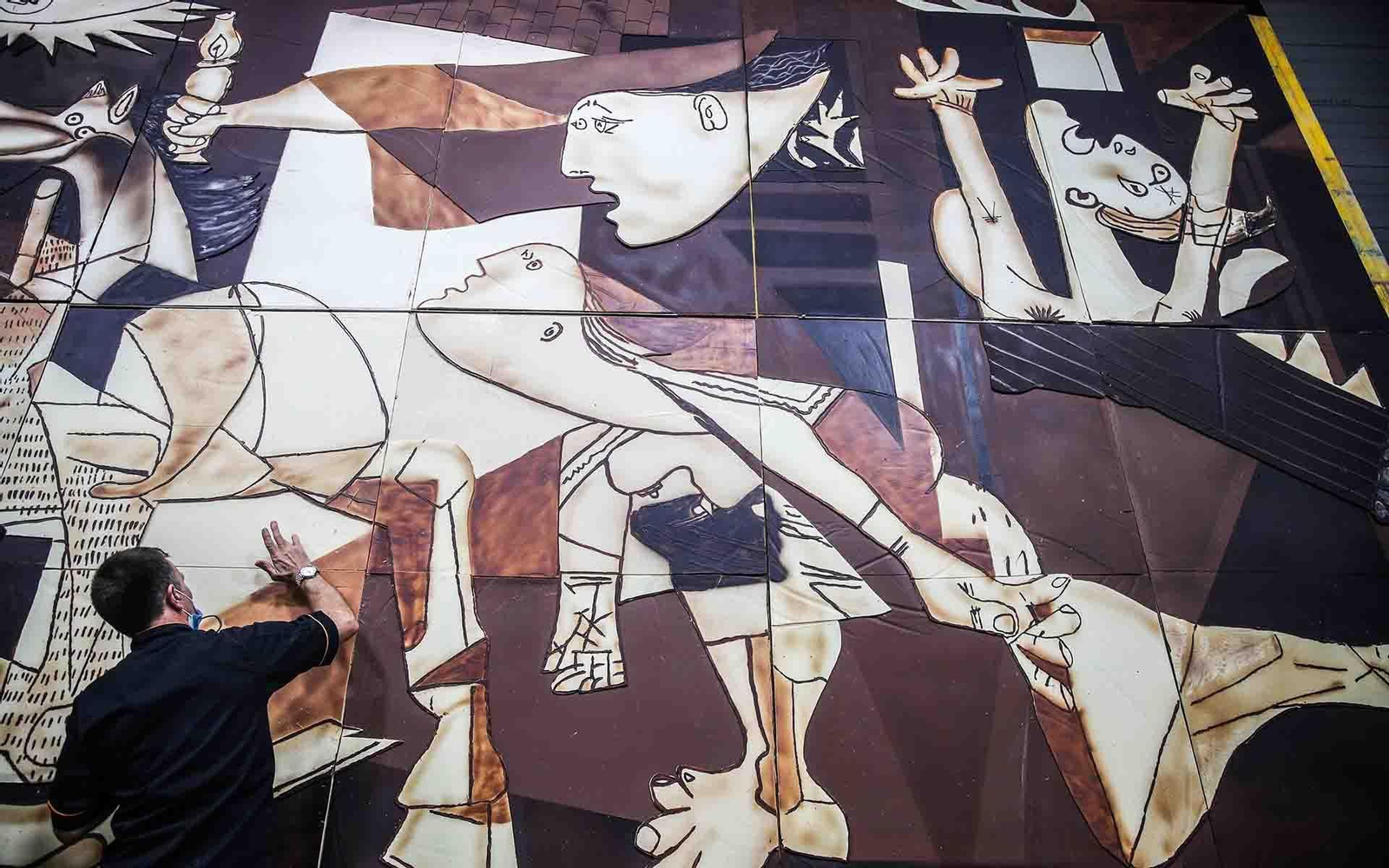 Un confitero prepara una de las partes de la versión en chocolate del Guernica de Pablo Picasso en el "Salon du Chocolat" de París. EFE/Mohammed Badra