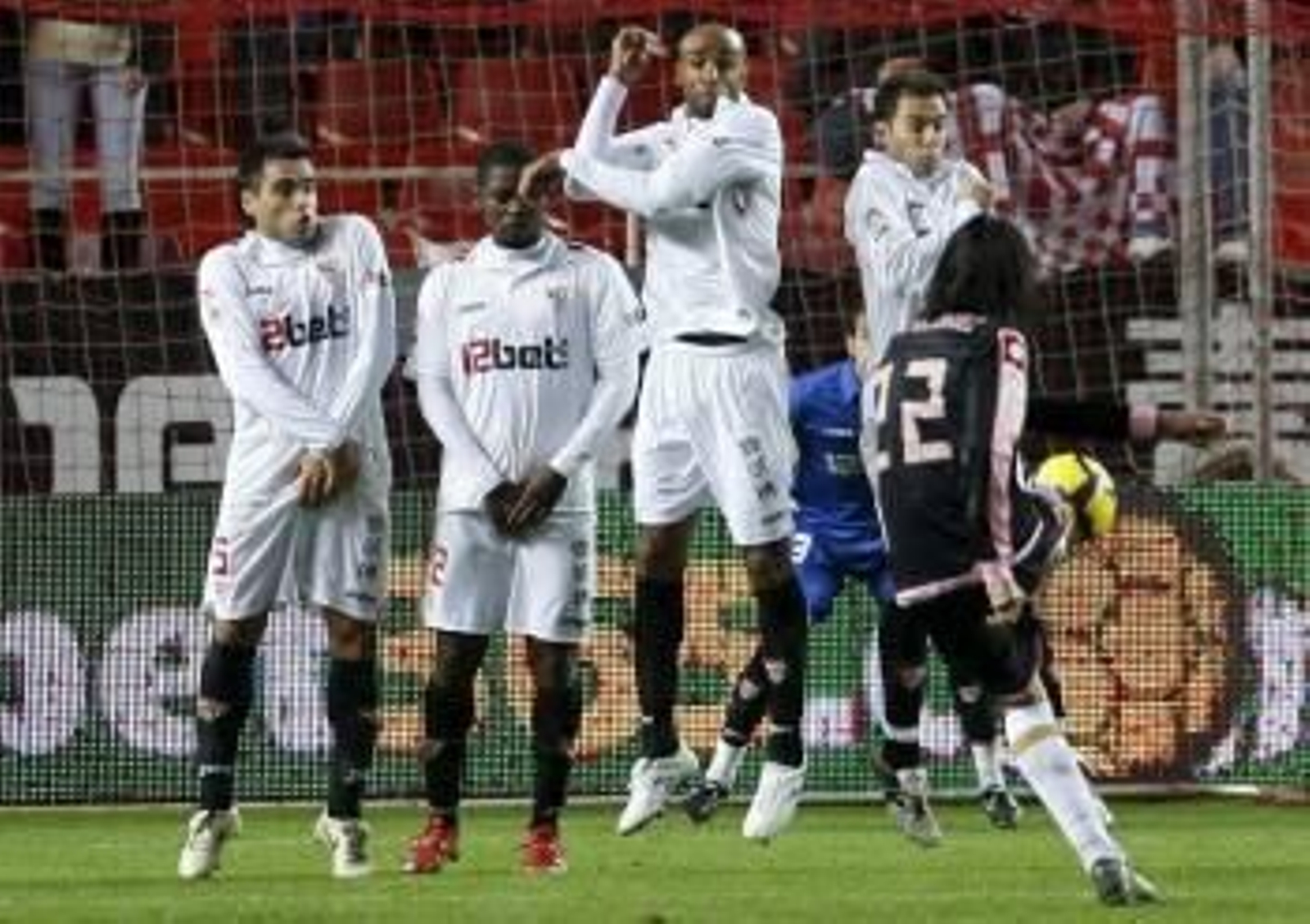 El jugador del Deportivo de la Coruña, Juán Rodriguez, intenta superar la barrera sevillista en el lanzamiento de una falta.