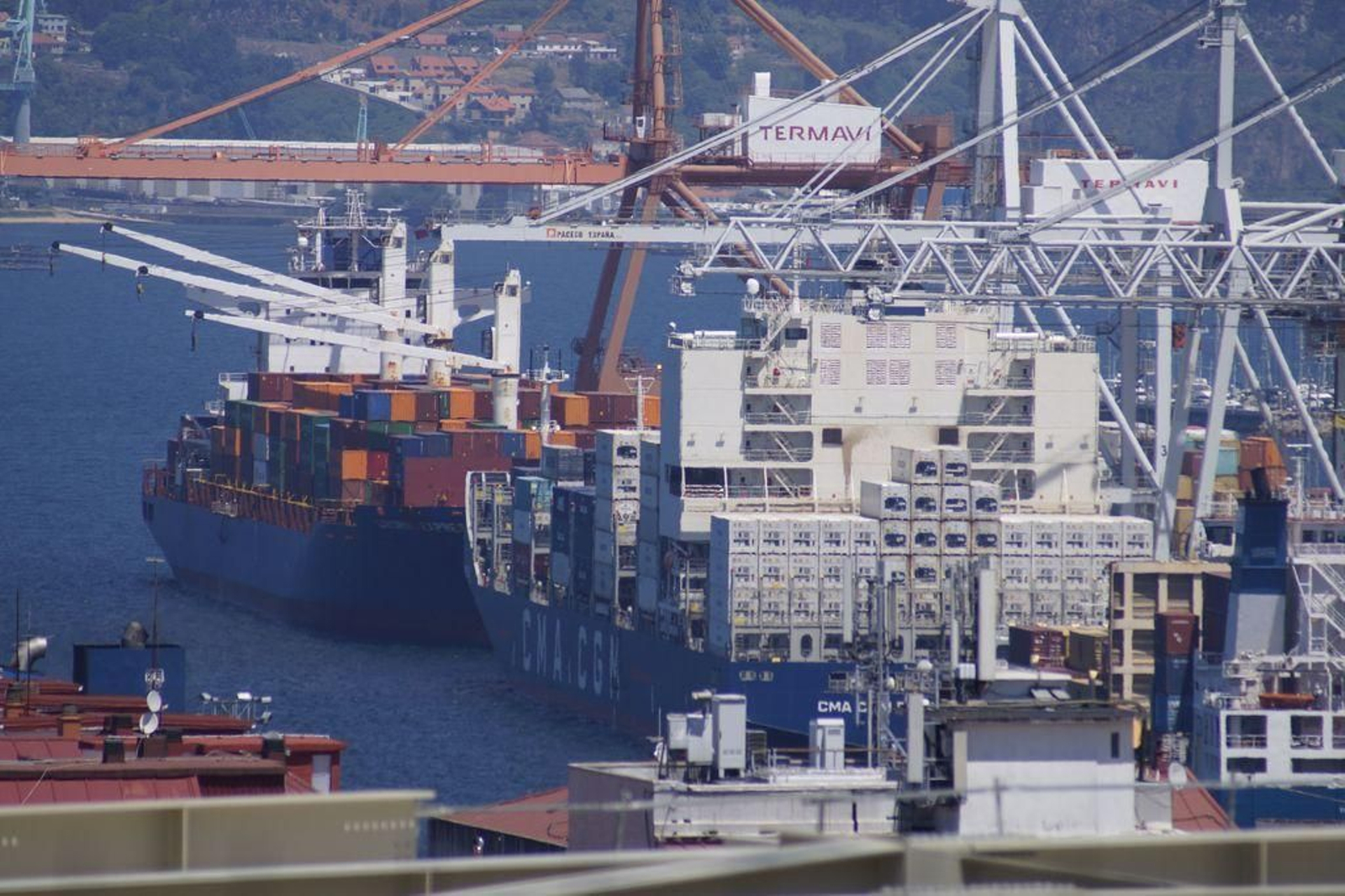 Tres barcos portacontenedores en la terminal de Guixar operando por la mañana.