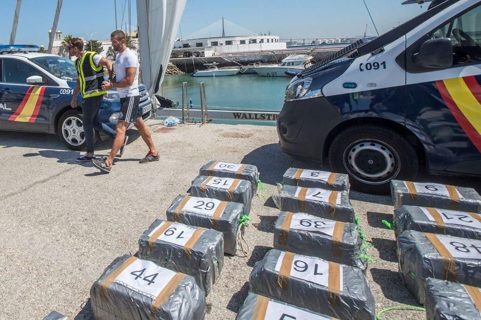 Imagen de la droga intervenida, trasladada a Cádiz, con uno de los detenidos.