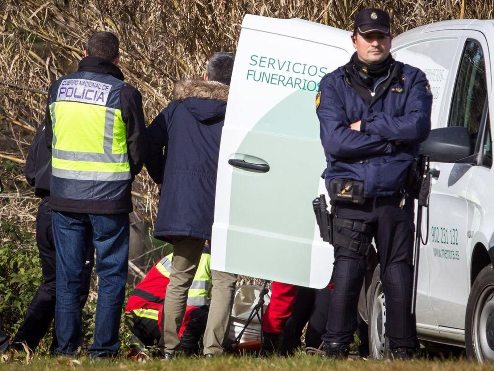 Agentes y sanitarios, durante el levantamiento del cadáver de la mujer.