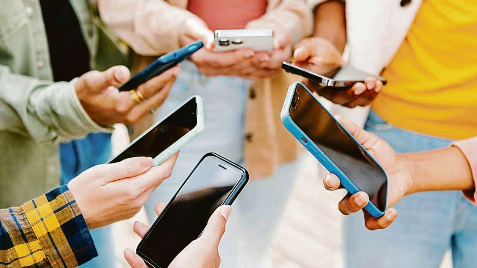Un grupo de jóvenes consulta sus teléfonos móviles.