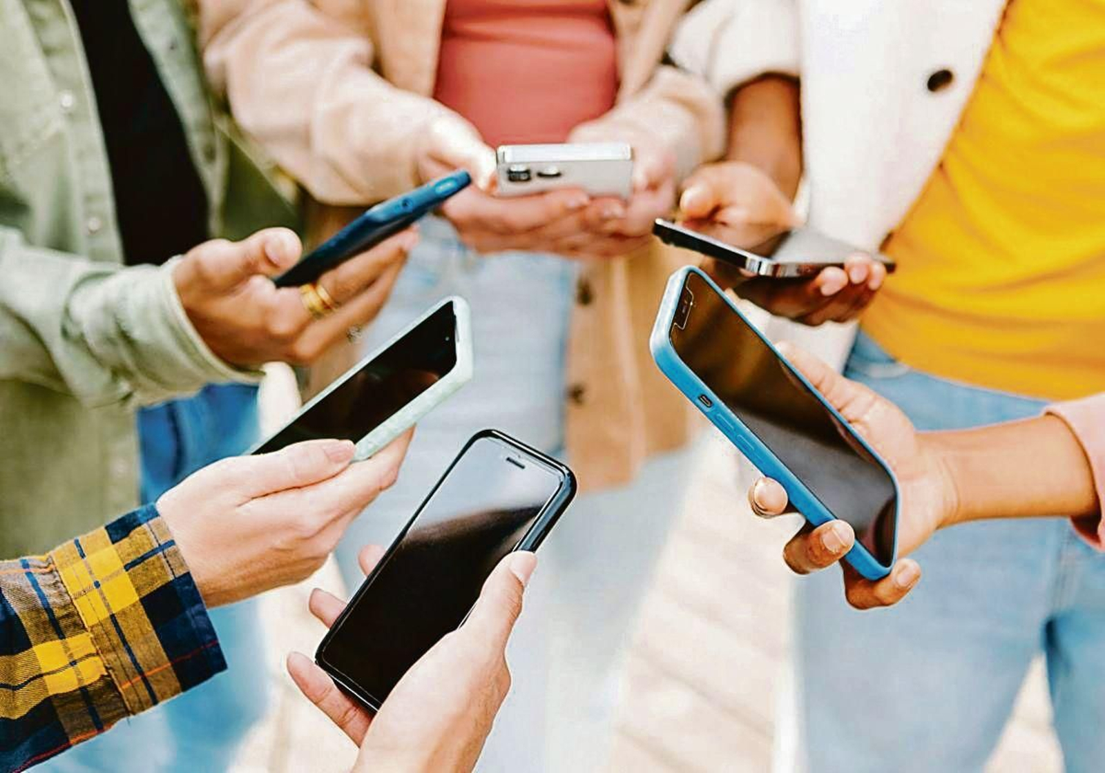Un grupo de jóvenes consulta sus teléfonos móviles en un descanso en la jornada lectiva.