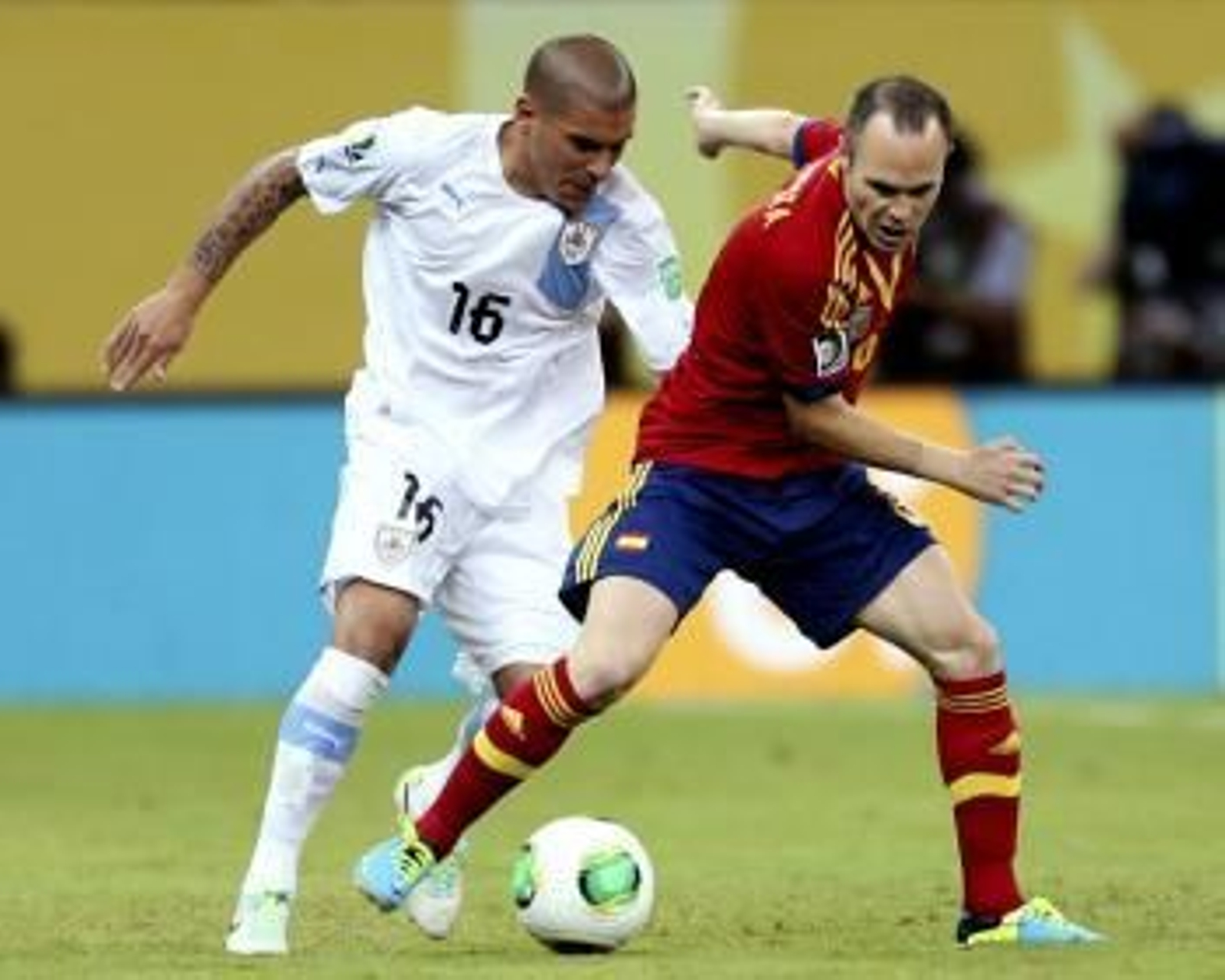 El centrocampista de la selección española Andrés Iniesta (d) pelea un balón con Maximiliano Pereira, de Uruguay (Foto: efe)