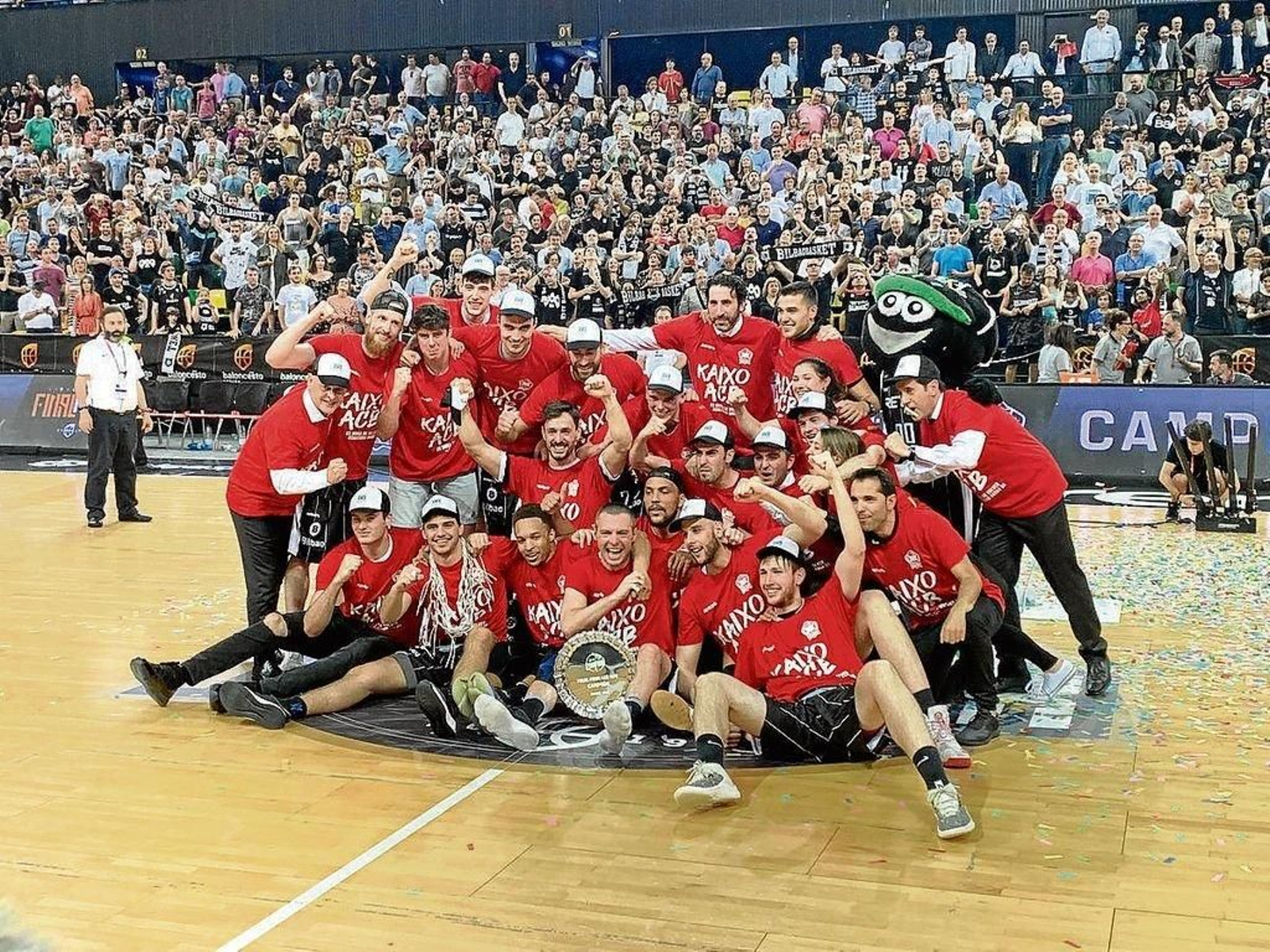 Jugadores y técnicos del Bilbao Basket celebran el triunfo en el centro de la pista.