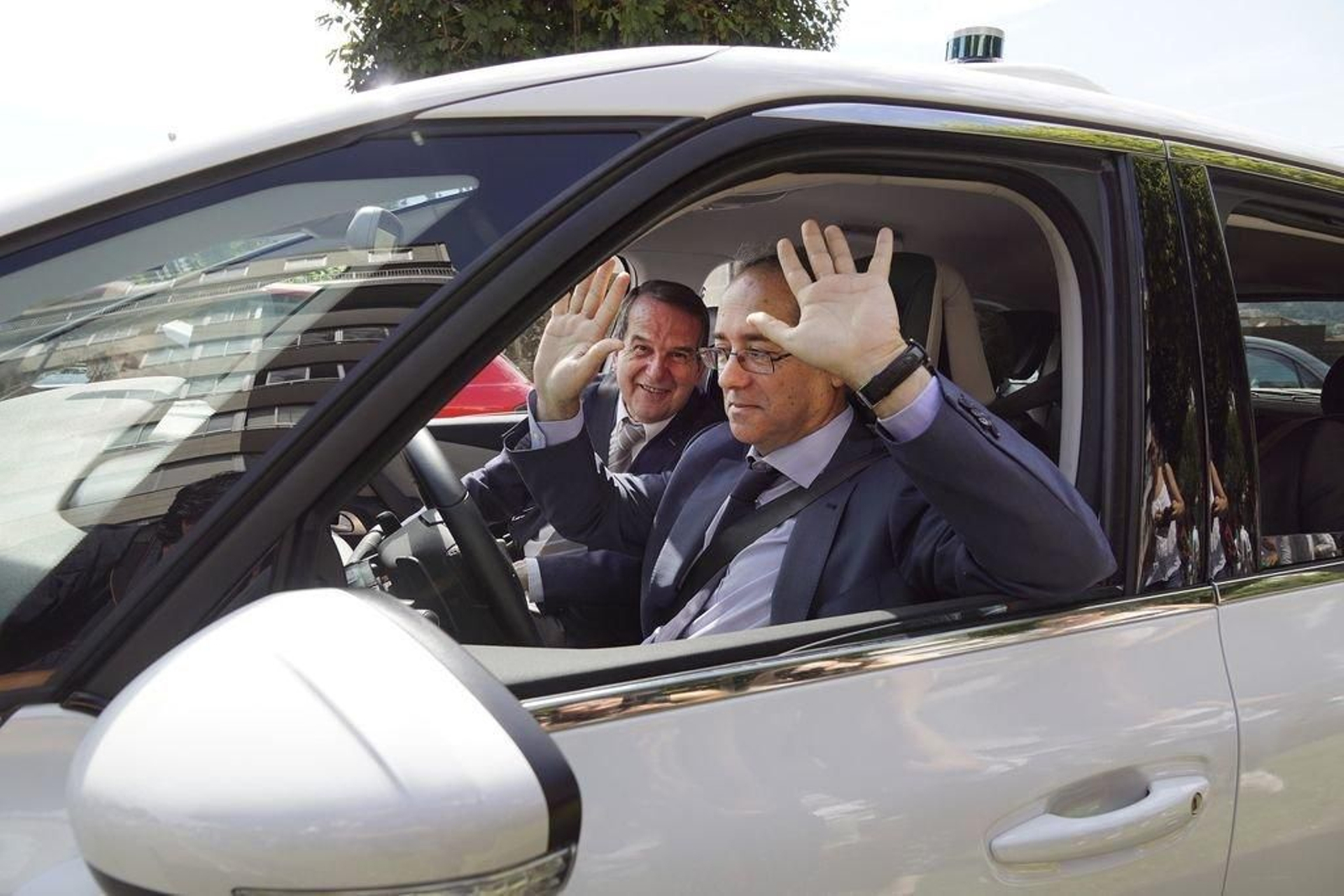 El director de electrónica del CTAG, con el alcalde de copiloto, muestra como el coche avanza sin tocar el volante.