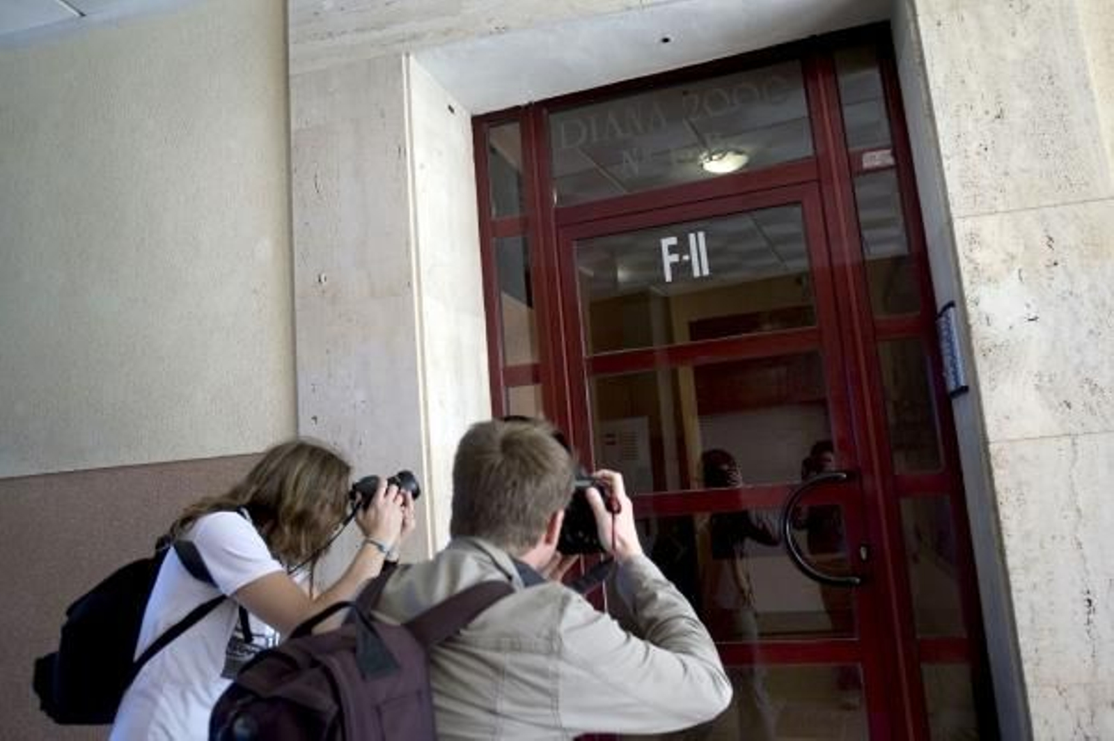 Dos fotógrafos toman imágenes del portal del edificio donde residía la pareja. (Foto: Rubén Francés)
