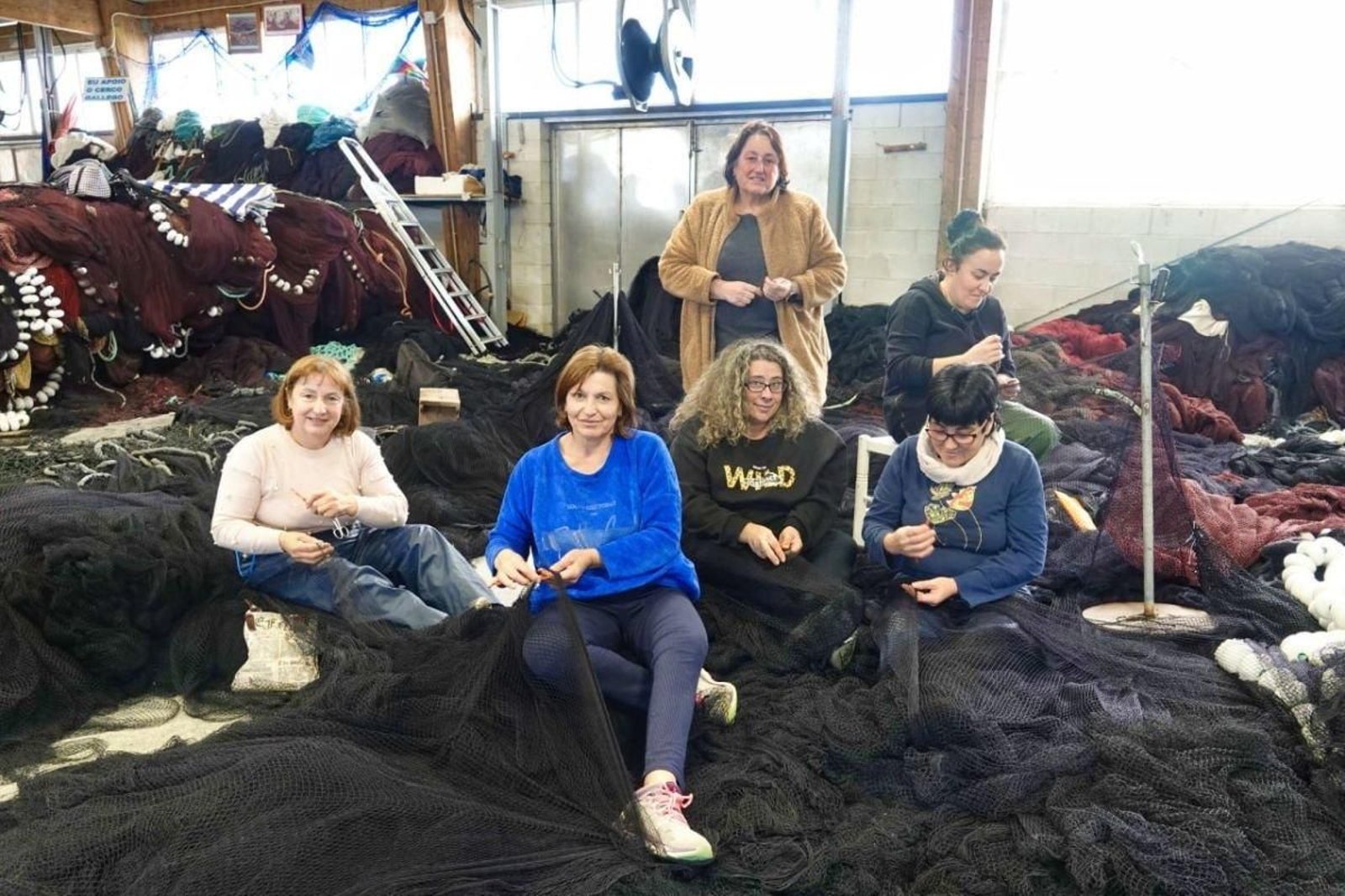 Un grupo de rederas de la asociación O Cerco de Cangas do Morrazo en plena faena con los aparejos de pesca.