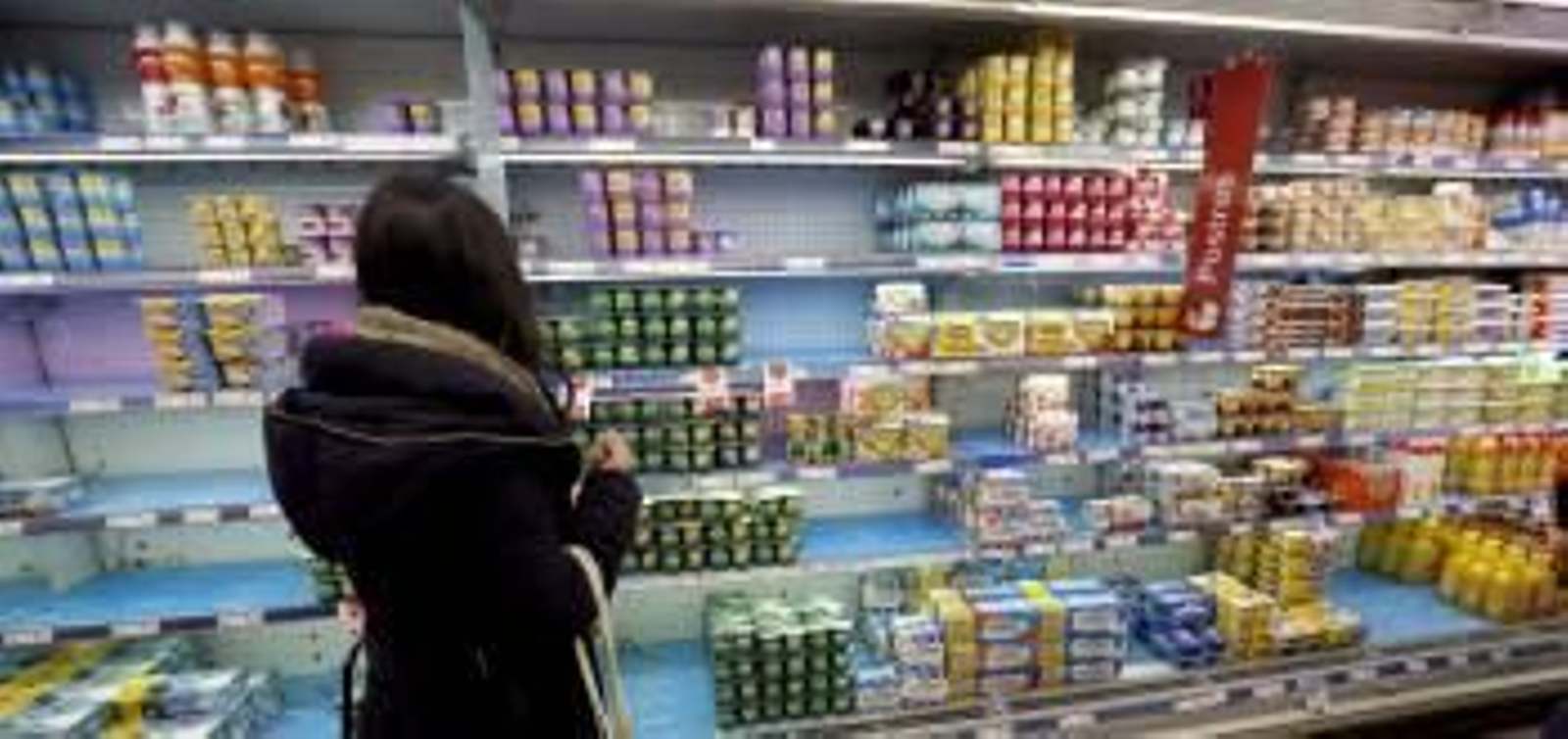 Una clienta de un supermercado busca en un panel repleto de yogures dispuestos para su venta. (Foto: JUANJO MARTÍN)