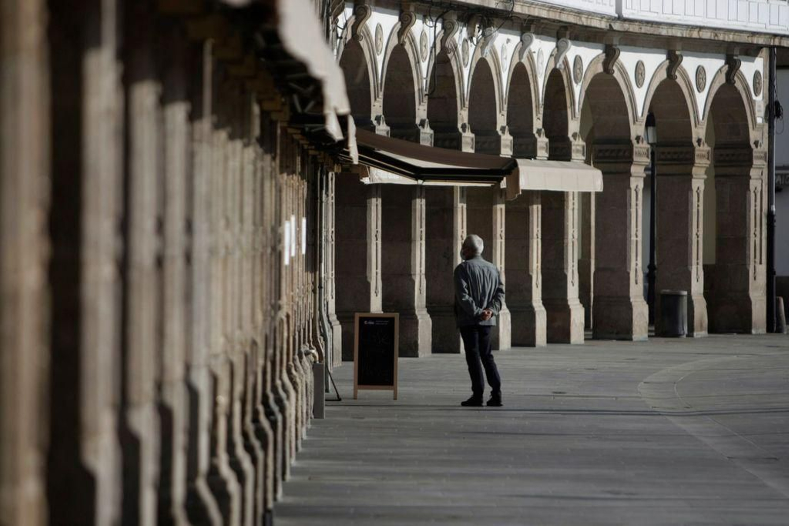 Un hombre espera que le sirvan un café para llevar en la zona de la Marina, en A Coruña.