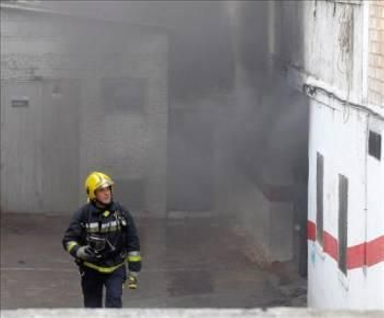 Un bombero trabaja en la extinción del incendio del garaje en Granada. (Foto: Miguel Ángel Molina)