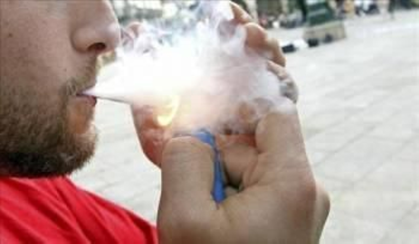 Una joven fumando un porro de marihuana en la calle.