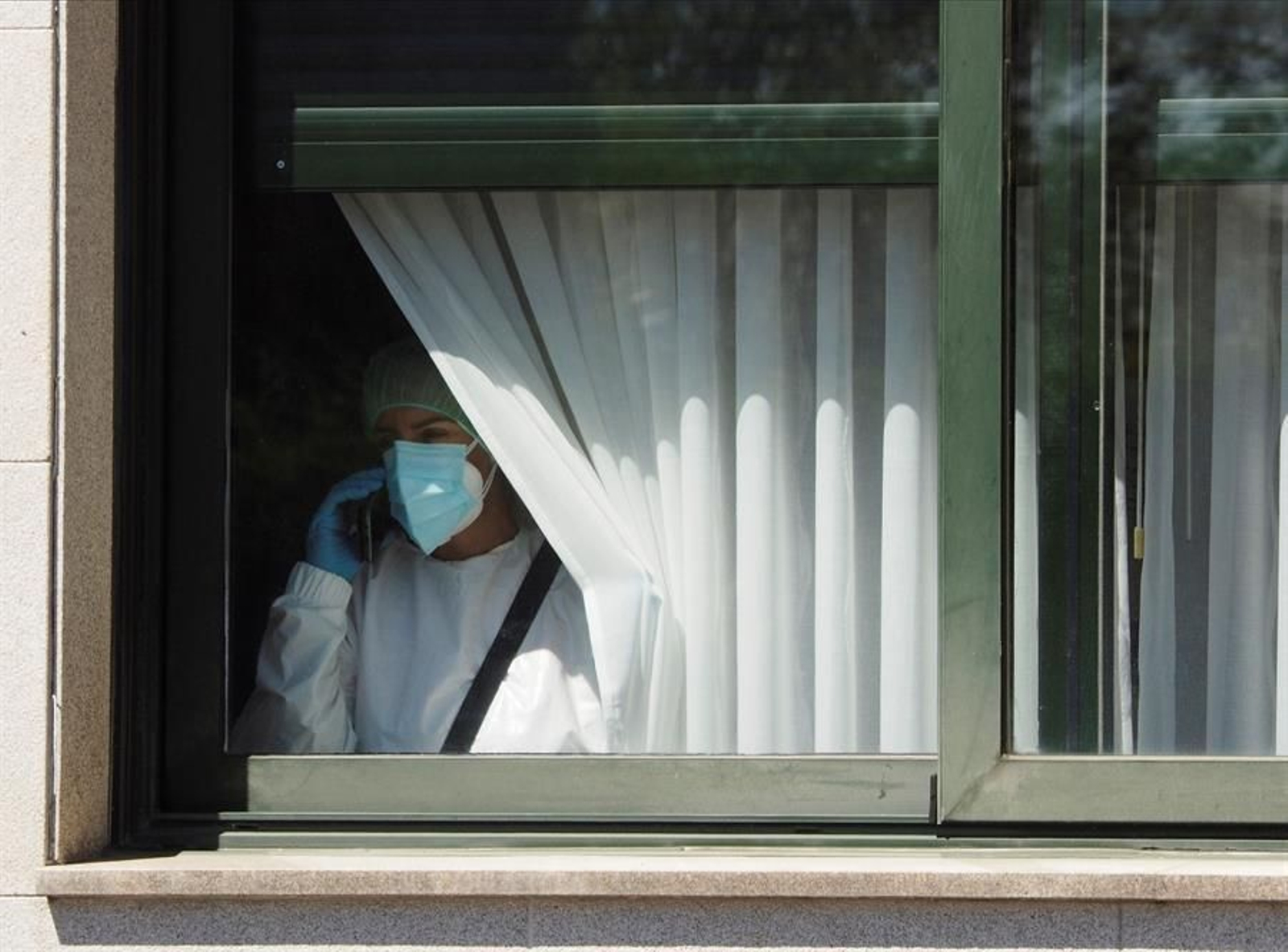 Una trabajadora sanitaria habla por teléfono este sábado desde el interior de la residencia de O Inicio (Lugo).