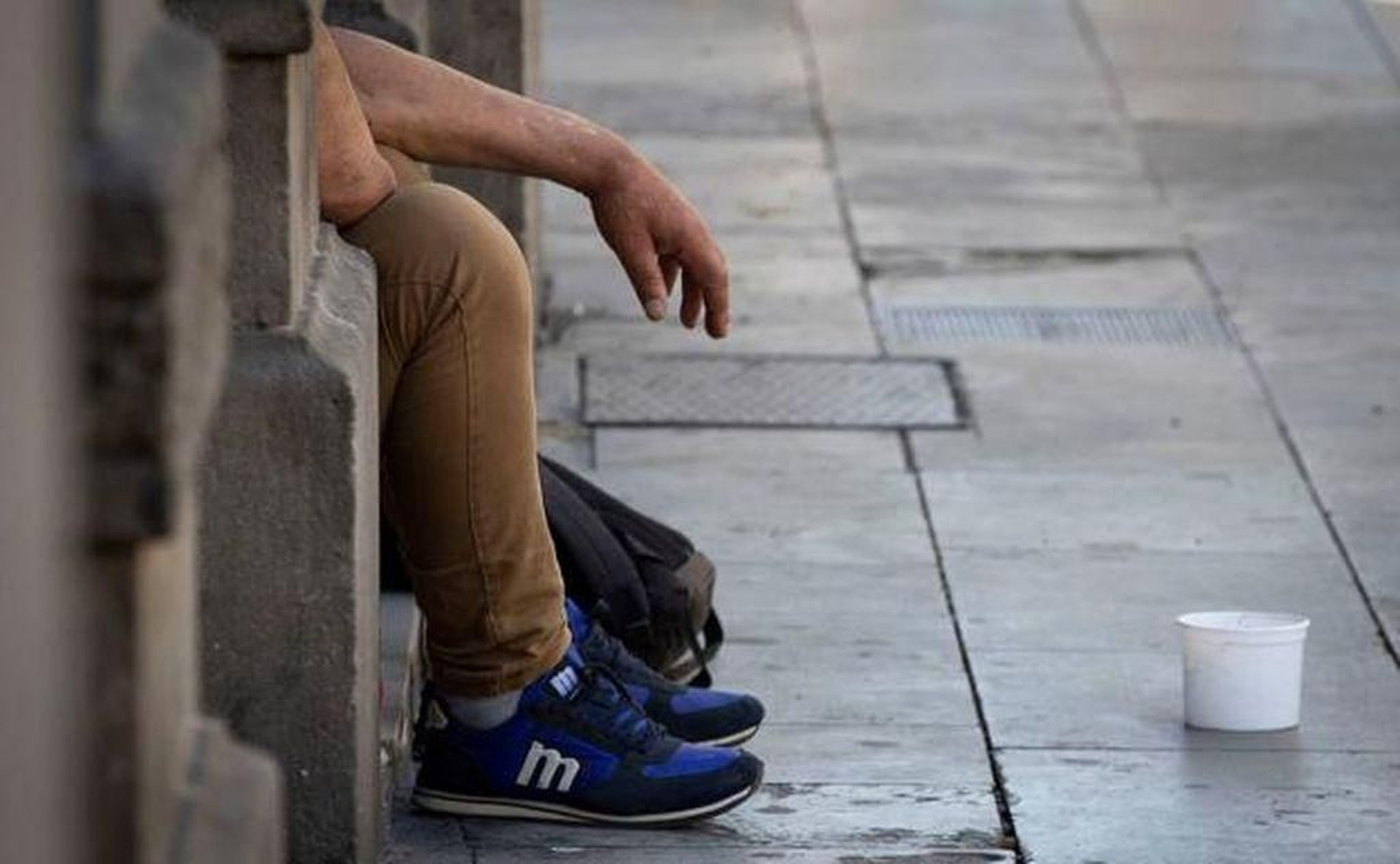 Un hombre pidiendo limosna en una calle de una ciudad española.
