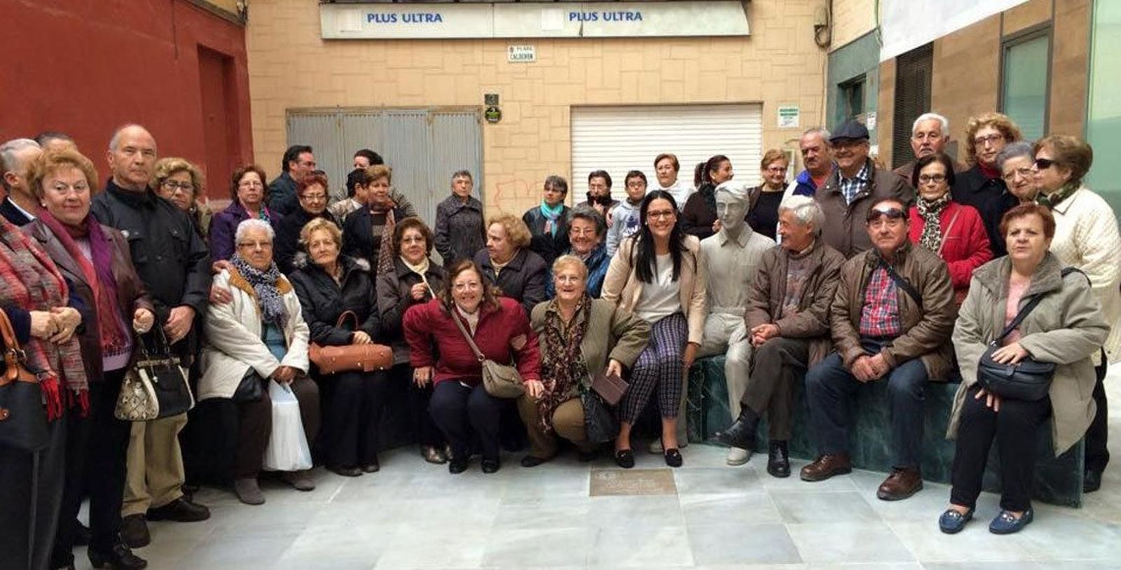 Los socios de ASALER junto a la estatua del emigrante retornado, en Almería..