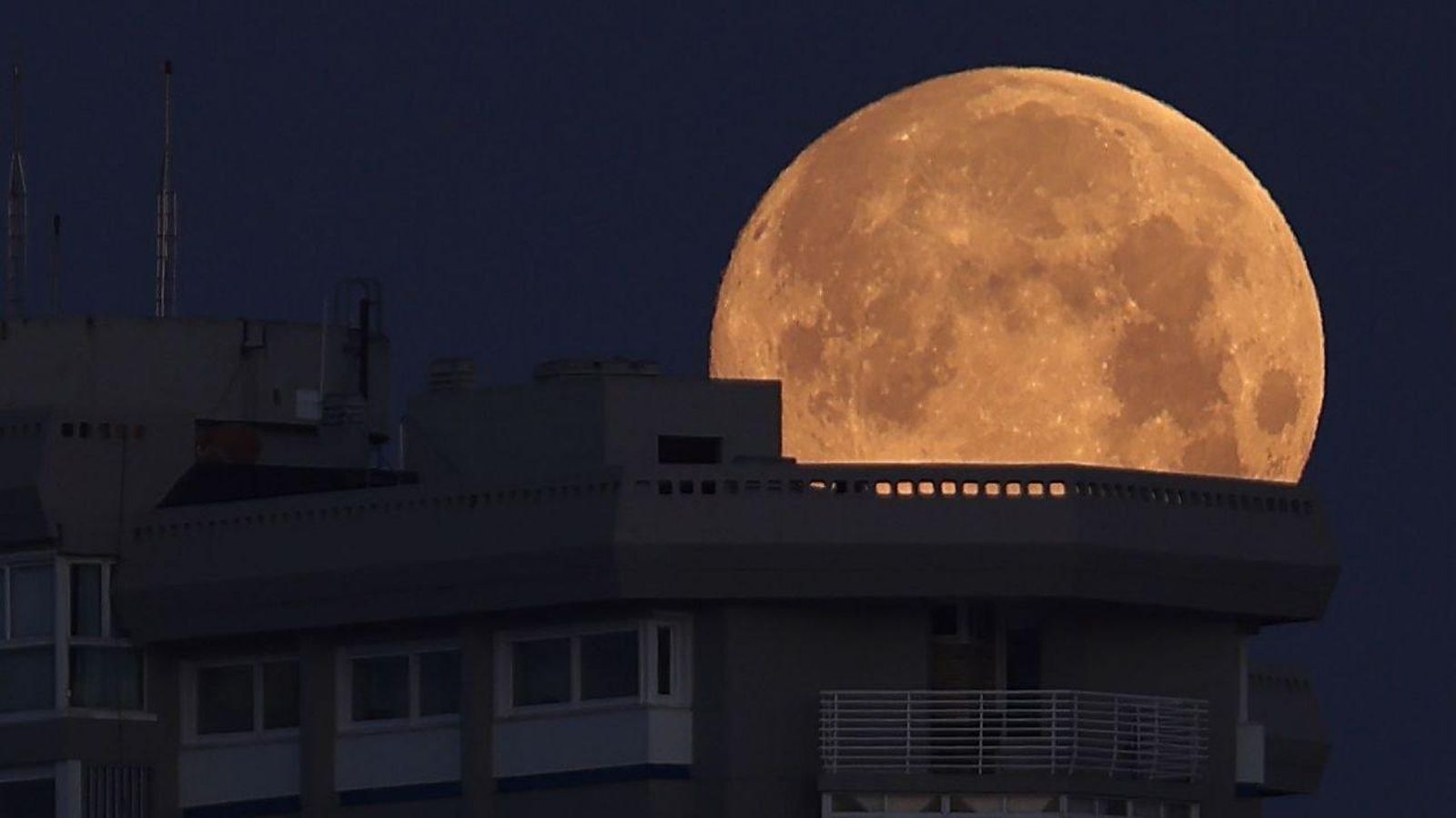La luna llena asoma por la azotea del edificio de Toralla en Vigo. // Alberte