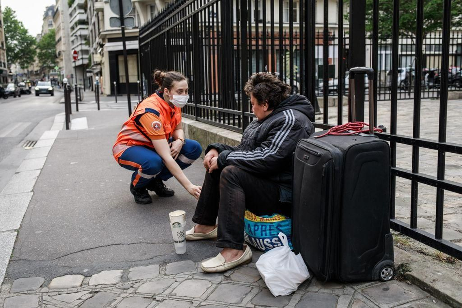 Una voluntaria de Protección Civil charla con una persona que vive en la calle en París.
