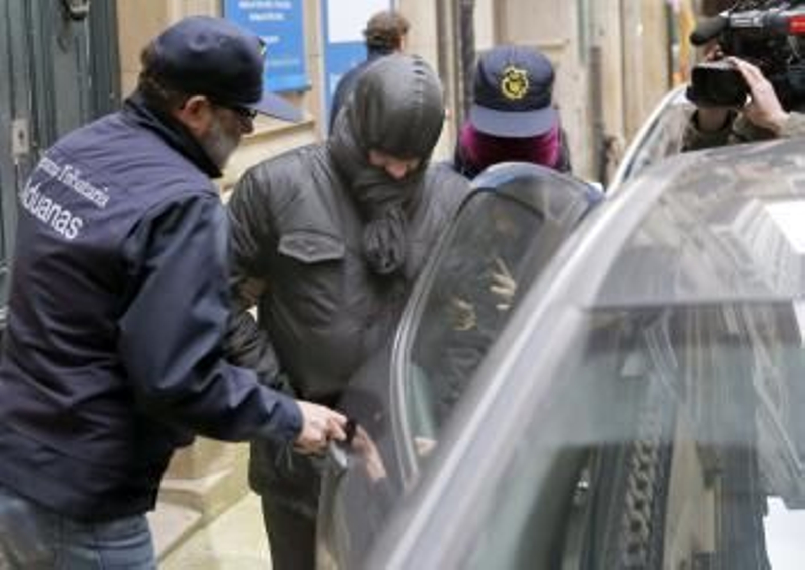 Agentes de Aduanas conducen detenido a un responsable de la oficina de Aquagest (Foto: EFE)