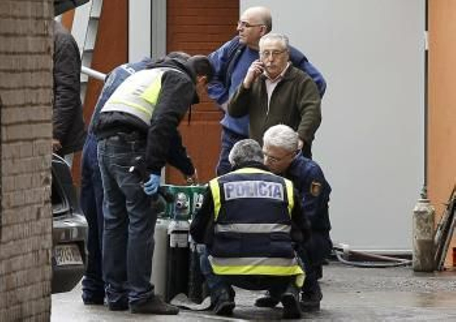 Agentes de Policía examinan unas botellas de oxígeno en la clínica madrileña de La Milagrosa, donde se encuentra ingresado el rey Juan Carlos.