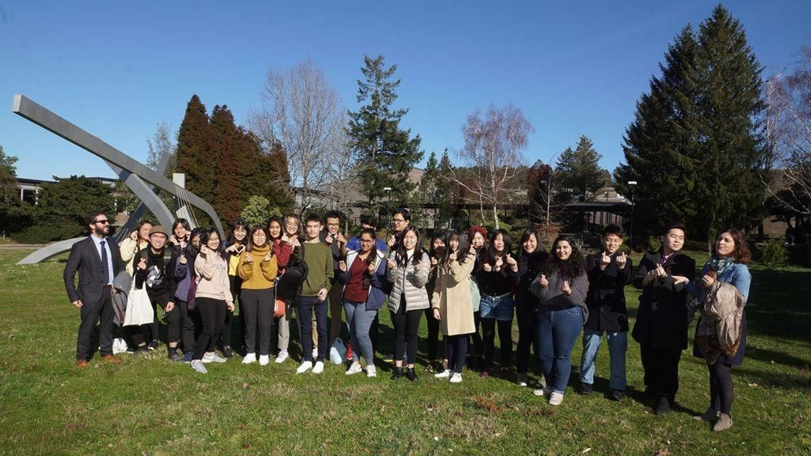 Los alumnos asiáticos, en el exterior de la Facultad de Filología y Traducción, haciendo el símbolo del corazón.