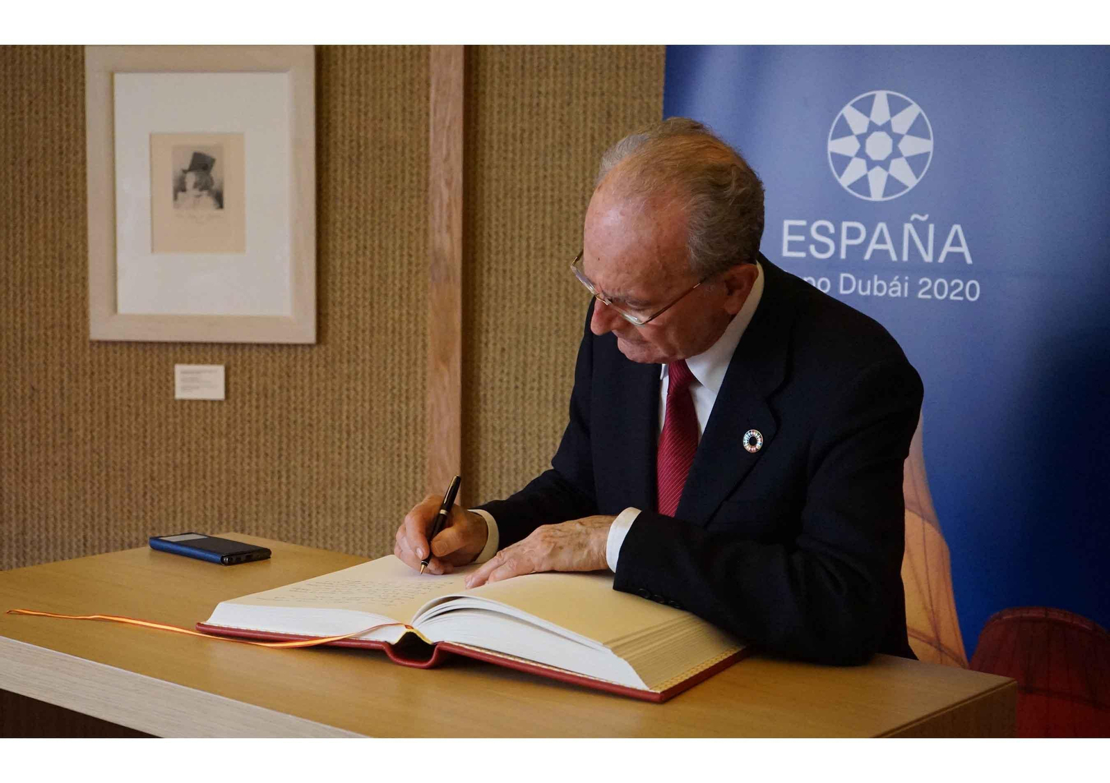 El alcalde de Málaga, Francisco de la Torre, firma en el libro de honor del pabellón de España en la Expo de Dubai, durante la visita del regidor para promover la candidatura malagueña de acoger la Exposición internacional de 2027. EFE / Iñigo Álvarez.