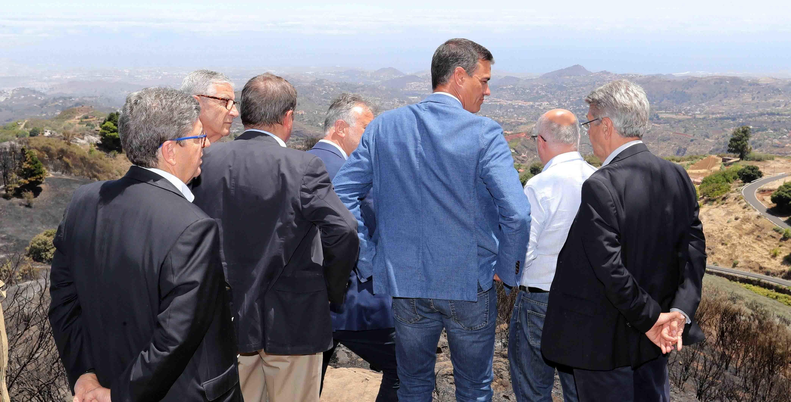 El presidente del Gobierno en funciones, Pedro Sánchez (c), junto a varias autoridades canarias, durante la visita que ha realizado a las zonas calcinadas por el incendio forestal que afecta a la isla de Gran Canaria. EFE/Elvira Urquijo A.