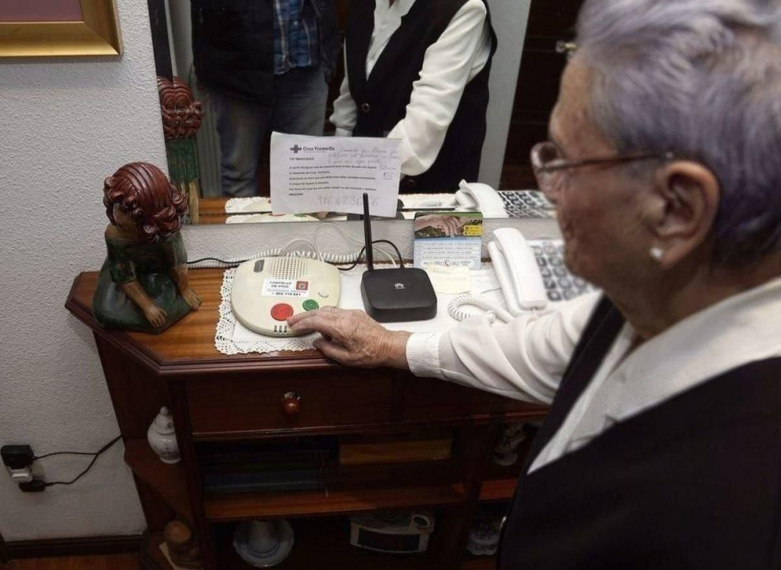 Una usuaria del servicio de teleasistencia con el terminal asociado a la telefonía fija.