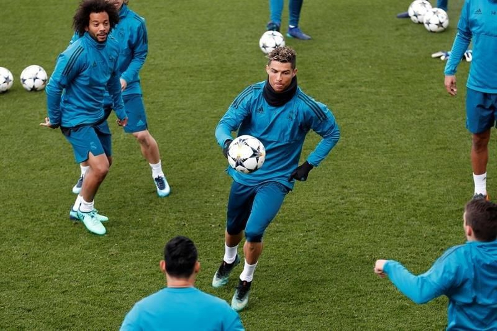 Cristiano Ronaldo persigue un balón en un rondo del entrenamiento de ayer ante la mirada de Marcelo.