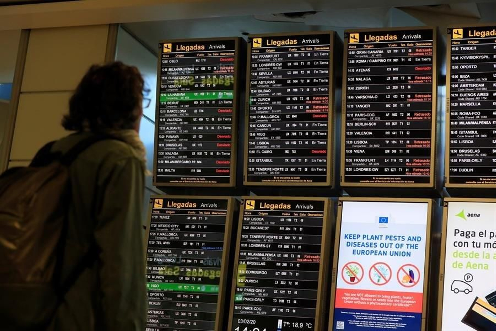 Un pasajero mira los paneles de información del aeropuerto Adolfo Suárez Madrid-Barajas en los que varios vuelos aparecen retrasados o desviados este lunes