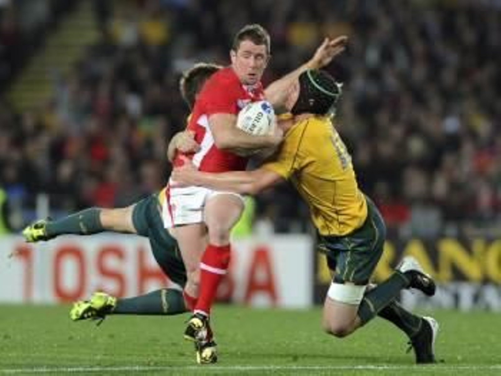 Los jugadores australianos Rob Horne (izq) y Berrick Barnes (dcha) placan al galés Shane Williams (c) durante el partido por el tercer puesto de la Copa del Mundo de rugby  (Foto: EFE)