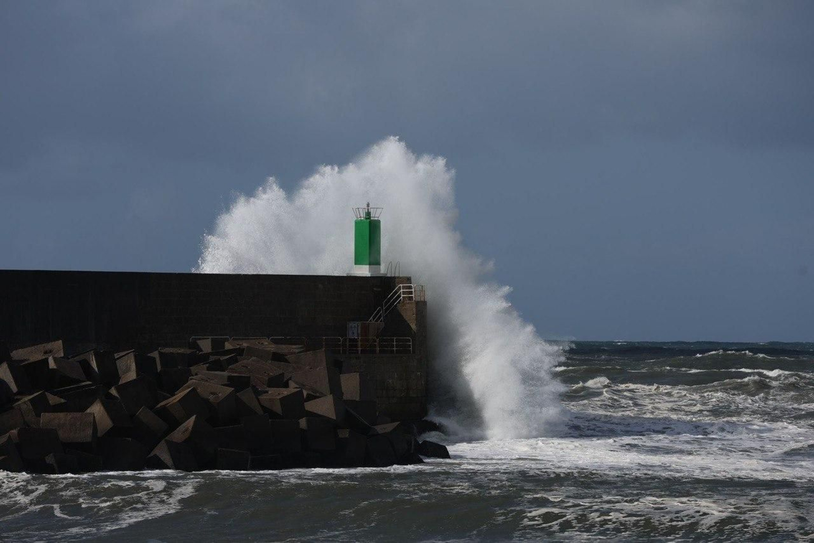 Una ola, de telón de fondo del espigón de A Guarda.
